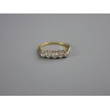 AN UNMARKED GOLD DRESS RING with five small diamonds, visual estimate 1.4 carats, 2.5 grms, size '