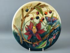 A MOORCROFT 'HARTGRING' 26 cms DIAMETER PLATE, decorated on a tonal cream and green ground,