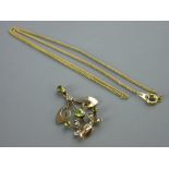 A NINE CARAT GOLD SCROLLED PENDANT with peridot and seed pearls, 1.5 grms and a yellow metal five