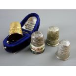 A CASED FLORAL DECORATED NINE CARAT GOLD THIMBLE, 4.5 grms, a silver and floral banded thimble, 7