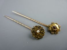 TWO YELLOW METAL STICK PINS, one with centre pearl and the other with a centre garnet