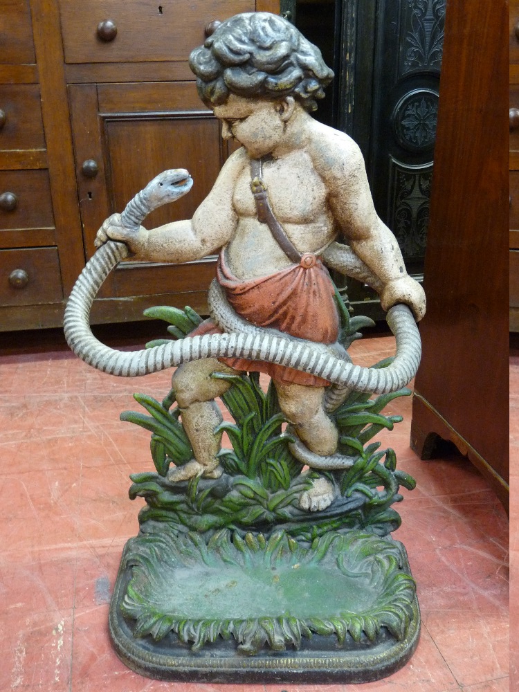 A VICTORIAN CAST IRON STICKSTAND modelled as a young Hercules wrestling a serpent, with pierced