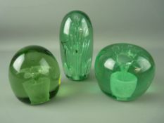 THREE VICTORIAN GREEN GLASS DUMP PAPERWEIGHTS, two having floral plantpot inclusions, the other with