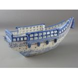 A CHINESE PORCELAIN BOAT, blue and white decorated with swirling waves and birds to the keel,