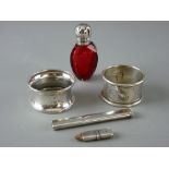 TWO BRIGHT CUT SILVER NAPKIN RINGS, 0.8 ozs, a silver handbag pencil and a silver topped cranberry