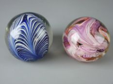 TWO LARGE VICTORIAN GLASS PAPERWEIGHTS with snapped and polished pontils, the interiors with