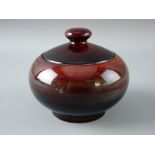 A MOORCROFT POTTERY POT & COVER of circular plain form, decorated in mottled blue to red tones,