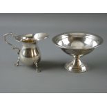 A PLAIN NARROW NECKED SILVER CREAM JUG on three pad supports with scrolled handle, 2.3 troy ozs,