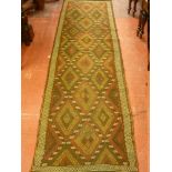 A SUZNI KILIM RUNNER, rust and red ground with repeating multi-diamond central pattern and narrow