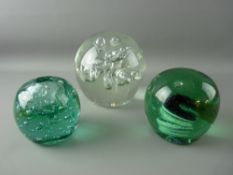 TWO VICTORIAN GREEN GLASS PAPERWEIGHTS & one other, one formed as an inkwell with bubble