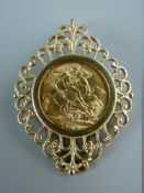 A 1914 GOLD SOVEREIGN in a filigree style scrolled mount, 14 grms