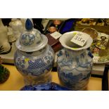 Two blue and white Oriental decorated vases, one lidded