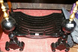 Cast iron fire basket on a pair of brass top dog irons