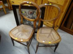A pair of balloon back chairs with cane seats & a vintage tapestry fire screen