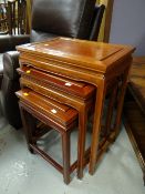 A modern rosewood-style nest of three coffee tables in the Chinese-style