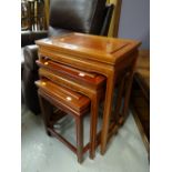 A modern rosewood-style nest of three coffee tables in the Chinese-style