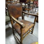 A distressed part leather turned wood elbow chair