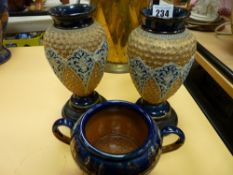 Pair of Royal Doulton Lambeth vases on hardwood stands and a similar twin handled bowl