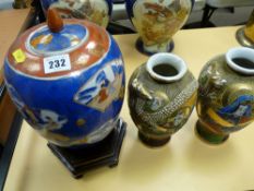 Lidded Oriental baluster vase on a hardwood stand and a pair of similar smaller vases