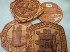 Four pottery wall plaques depicting North Walian historical buildings