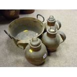 Three copper jugs and a brass jam pan with iron handle