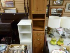 Light wood effect modern narrow cupboard with central drawers and a similar shaped white bathroom