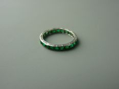 A PLATINUM & EMERALD FULL ETERNITY RING having approximately twenty three square faceted emeralds,