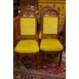 A SET OF FOUR OAK GOTHIC STYLE SIDE CHAIRS with arched top pierced back rail and lower frieze,