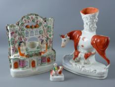 THREE STAFFORDSHIRE POTTERY ORNAMENTS including a cow and calf spillholder, a castle top pocket