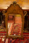 A GEORGIAN STYLE REPRODUCTION WALNUT WALL MIRROR, the shaped frame with shell and leaf applied