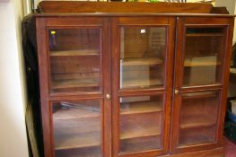 A VICTORIAN MAHOGANY FLOORSTANDING BOOKCASE with a gallery top over three twin glazed panel doors