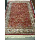 A RED GROUND KASHMIR RUG with Tree of Life design and tasselled ends, 170 x 118 cms