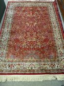 A RED GROUND KASHMIR RUG with Tree of Life design and tasselled ends, 170 x 118 cms