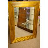 A LARGE REPRODUCTION GILT FRAMED WALL MIRROR of rectangular form with reeded decoration and bevelled