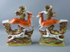 A PAIR OF 19th CENTURY STAFFORDSHIRE FLATBACK LEAPING DEER SPILLHOLDERS, opposing figures with