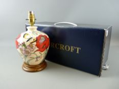 A MOORCROFT 'FAMILY THROUGH FLOWERS' TABLE LAMP, decorated on an ivory ground, set on a wooden base,