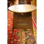 AN UNUSUAL STAINED PINE CIRCULAR TOPPED CRICKET TABLE with enclosed cupboard base, 63 cms diameter