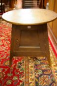 AN UNUSUAL STAINED PINE CIRCULAR TOPPED CRICKET TABLE with enclosed cupboard base, 63 cms diameter