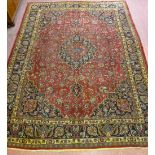 A LARGE RED GROUND PERSIAN MASHAD CARPET with Trad medallion design and multiple border, 390 x 288