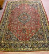 A LARGE RED GROUND PERSIAN MASHAD CARPET with Trad medallion design and multiple border, 390 x 288