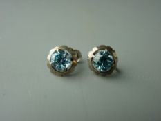 A PAIR OF STERLING SILVER BLUE ZIRCON STUD EARRINGS, the round faceted stones of approximately 7 x 7