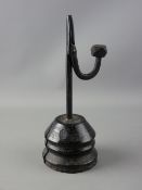 AN ANTIQUE IRON RUSH LIGHT NIP on a turned conical base, the nip arm with faceted weight, the base