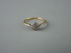 AN EIGHTEEN CARAT GOLD LADY'S DIAMOND CLUSTER RING having seven tiny diamonds in a floral cluster,