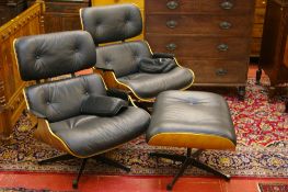 A CHARLES & RAY EAMES STYLE SUITE OF TWO ARMCHAIRS AND A FOOTSTOOL, an iconic style set in shaped