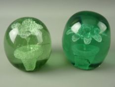 TWO VICTORIAN GREEN GLASS DUMP PAPERWEIGHTS with single stem in pot flower inclusions, 10.5 cms high