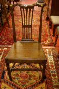 A CIRCA 1800 OAK FARMHOUSE CHAIR with shaped top rail and pierced splatback, on square supports with