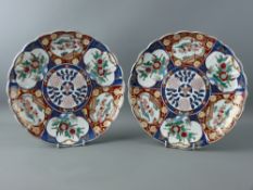 A PAIR OF JAPANESE IMARI DECORATED PORCELAIN CHARGERS having segmented panels with foliate and