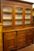 A NORTH WALES VICTORIAN OAK & MAHOGANY GLASS TOP BREAKFRONT DRESSER, the shaped cornice over a block