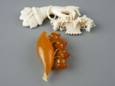 TWO VINTAGE CARVED LADY'S BROOCHES, one as a hand holding a basket of grapes, possibly ivory or
