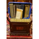 AN EDWARDIAN INLAID MUSIC STOOL with twin carry handles and upholstered seat over a single lower